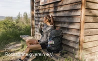 Wanderin macht Pause an der Schutzhütte am Aussichtspunkt "Westerwaldblick"